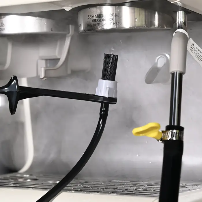 Le barista utilise un buse à vapeur d'une machine à café de qualité alimentaire résistante à la chaleur pour nettoyer